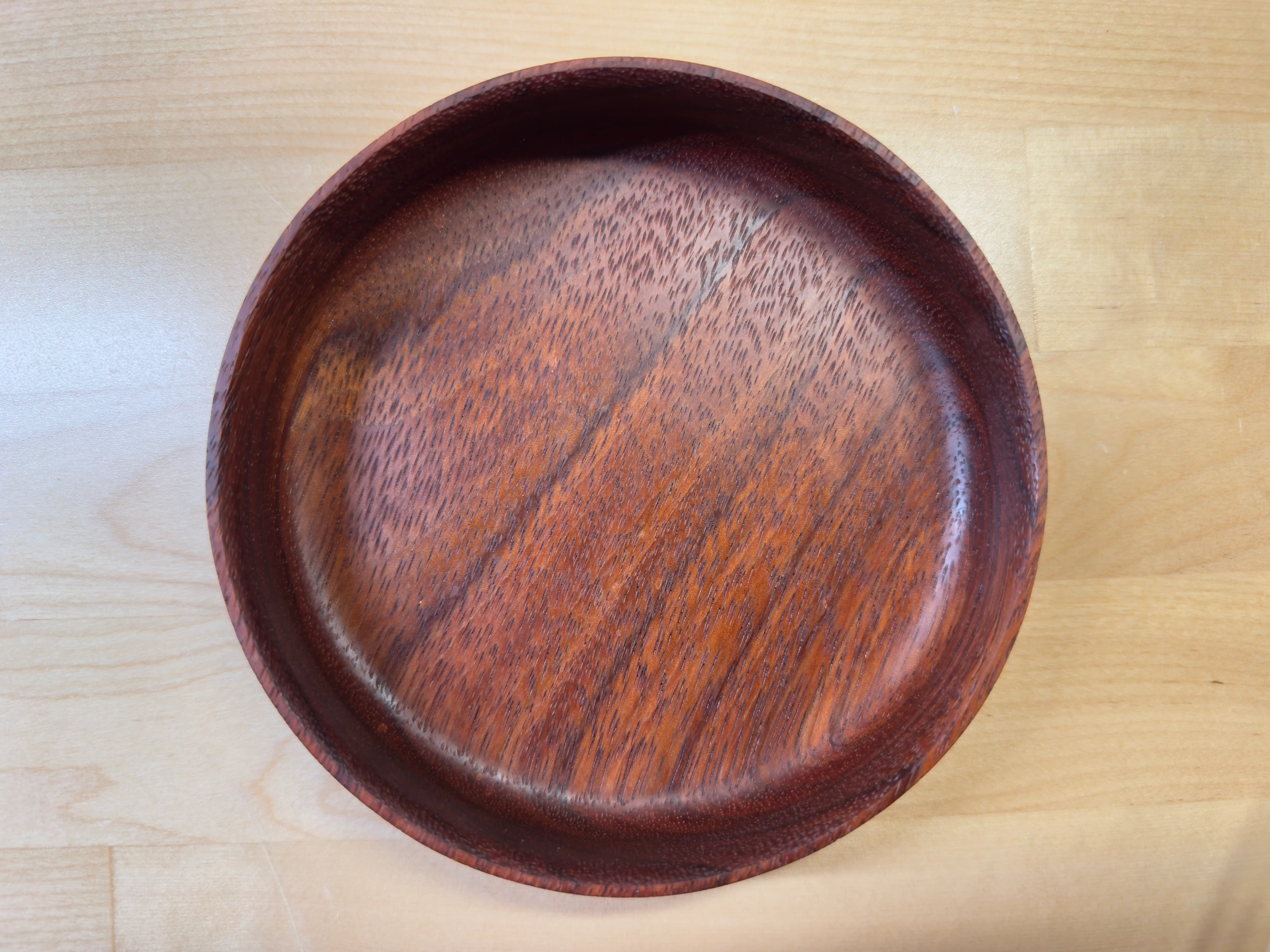 A handmade shallow knickknack tray made out of exotic wood.